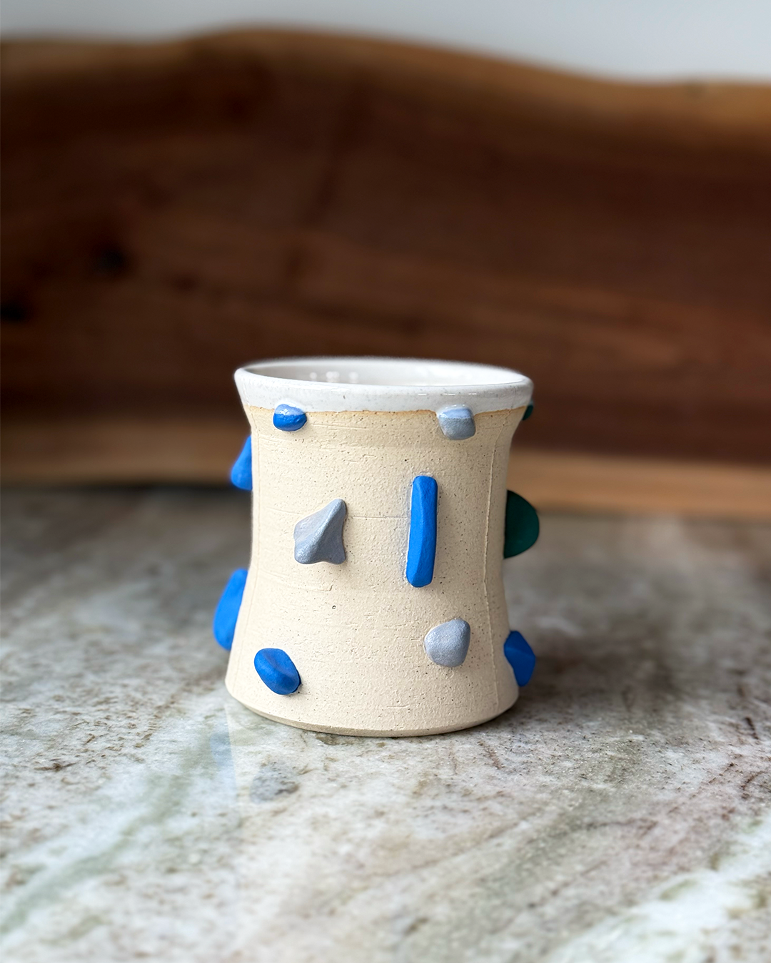 Mug Inspired by a climbing wall white glaze inside a marble and wood backdrop
