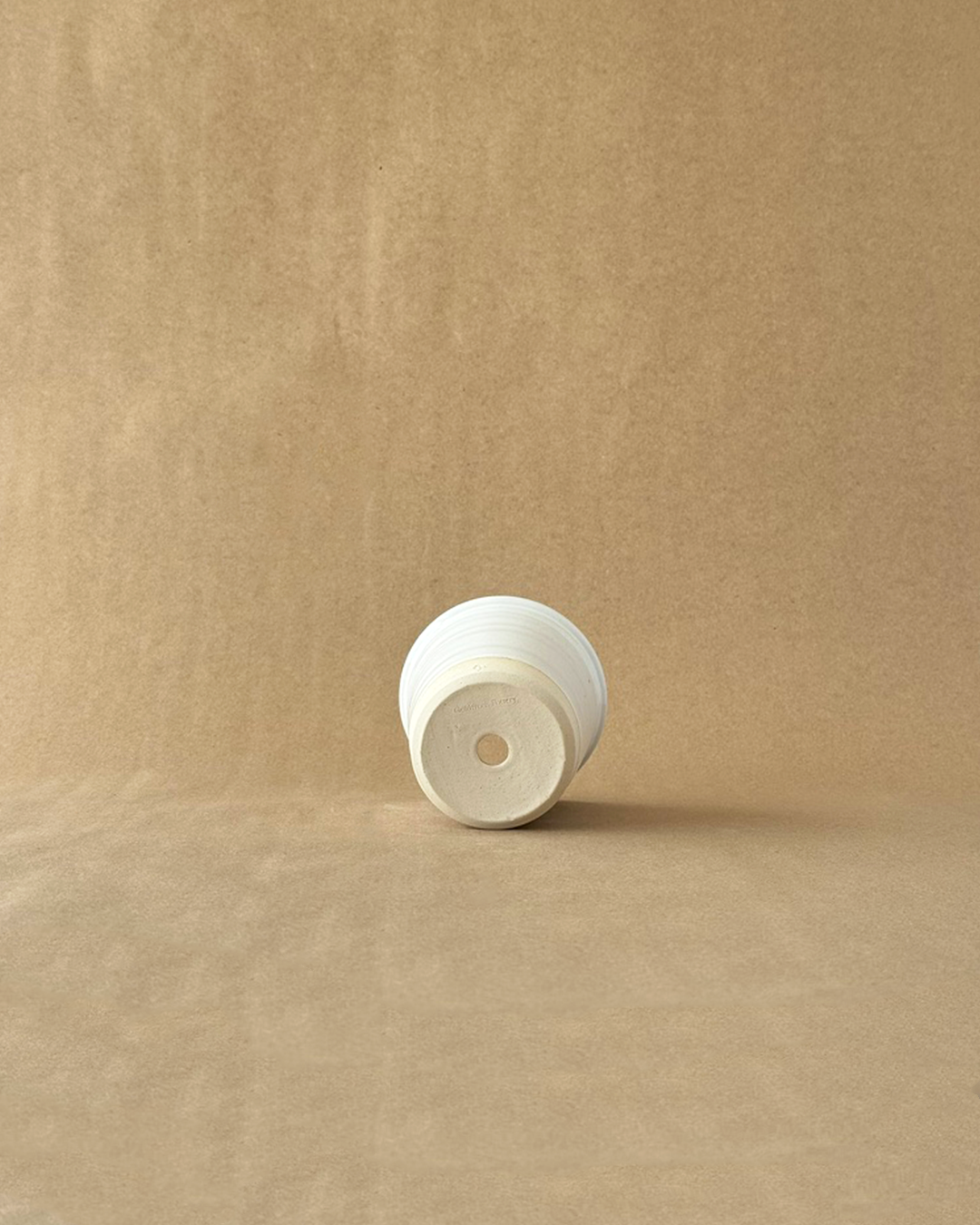 White ceramic garden pot on a brown background