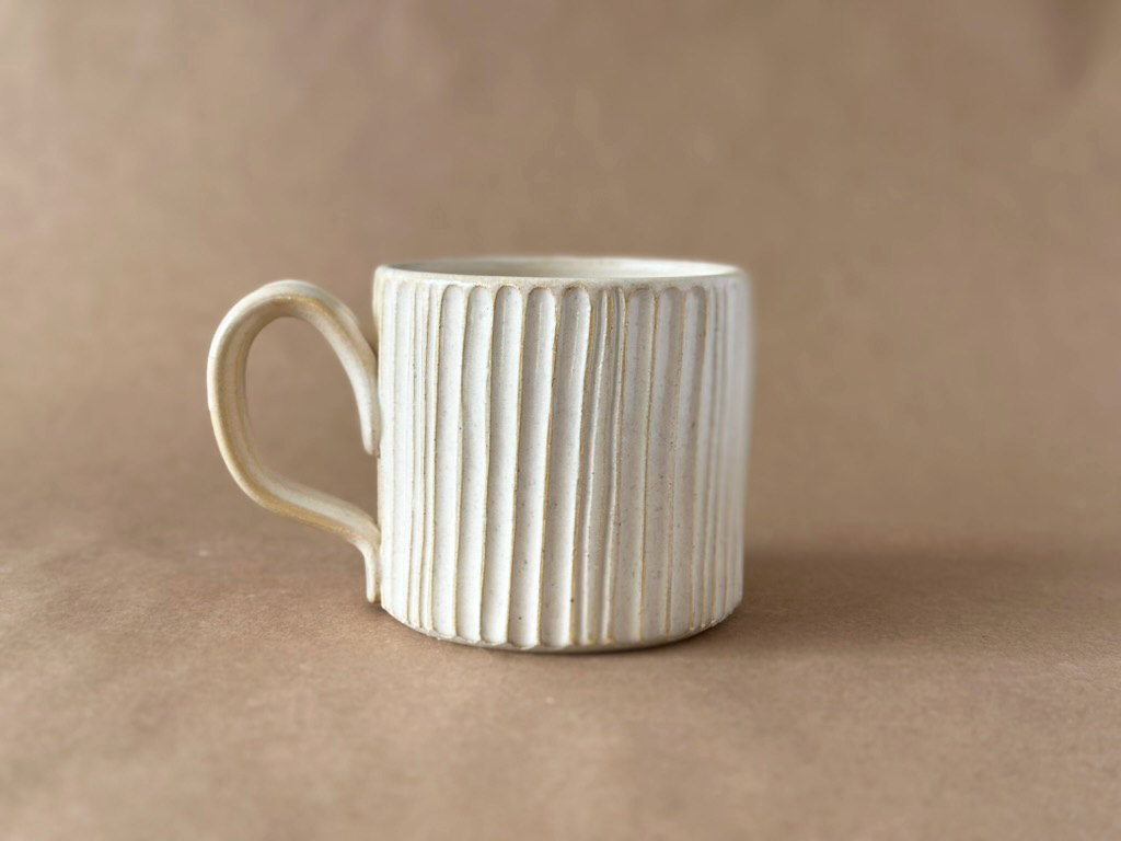 Linen Natural Carved Mug on brown backdrop