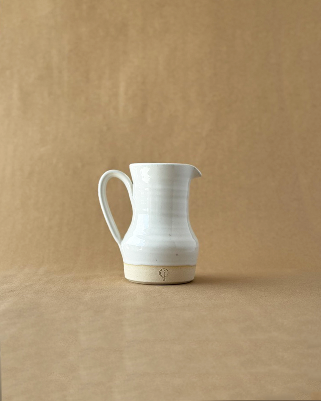 White Pitcher on a brown backdrop