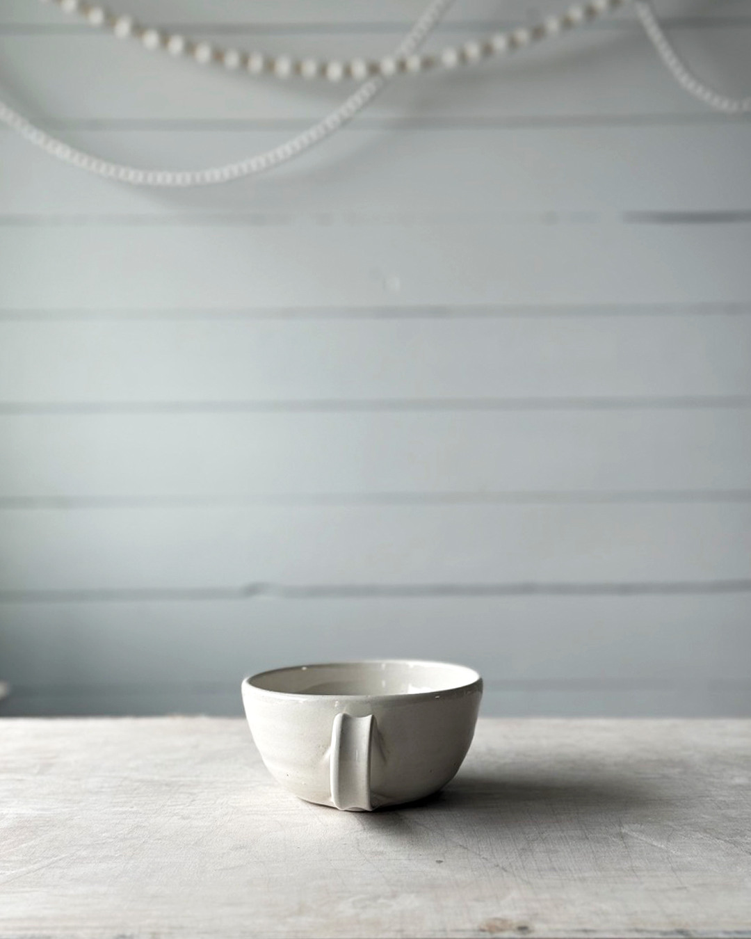 White ceramic bowl on a wooden surface with a gray background