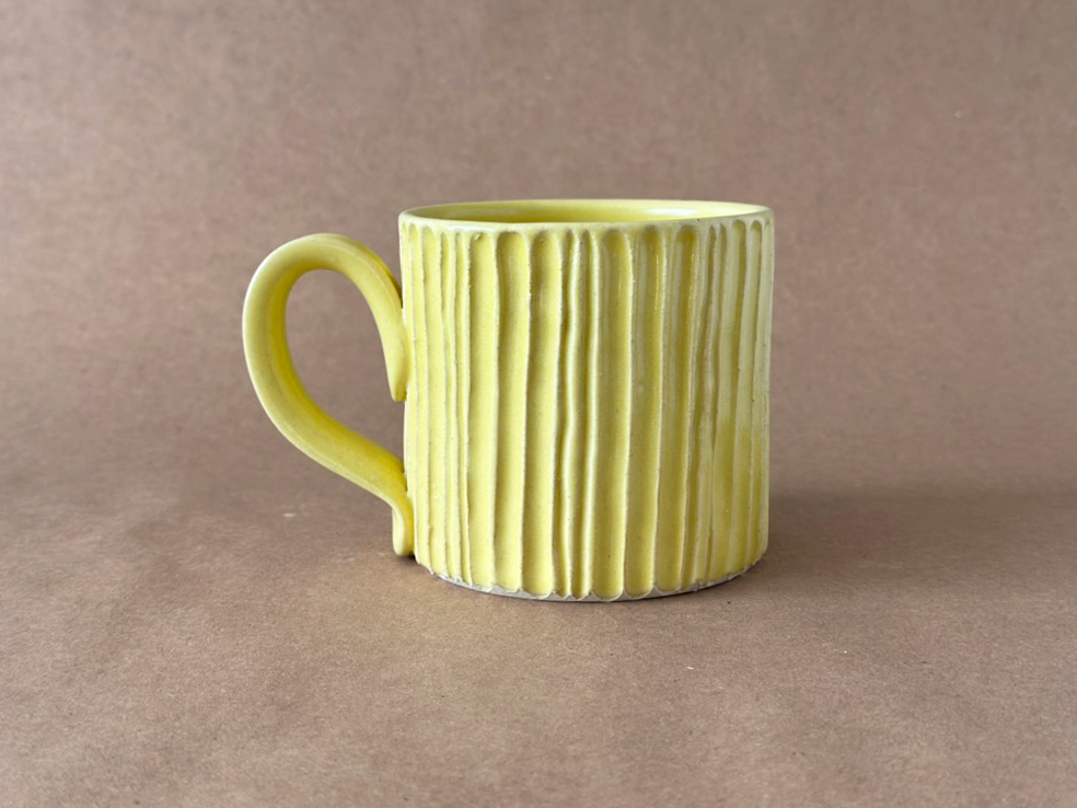 Yellow Carved mug with a brown backdrop