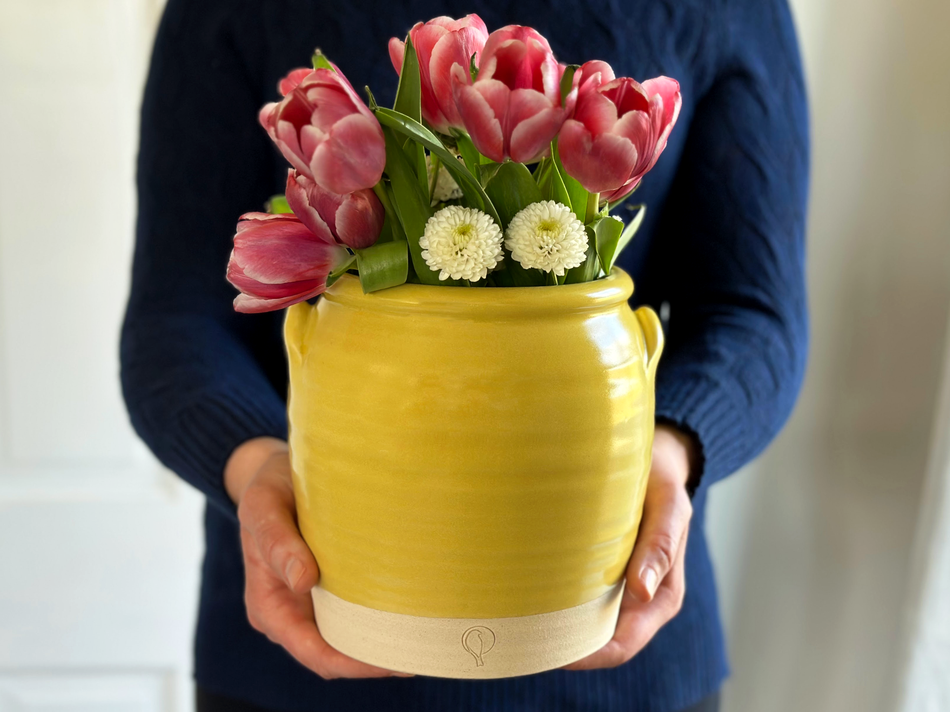 https://goldfinchpottery.com/cdn/shop/products/HoldingYellowCrock2023.png?v=1678841733&width=1946